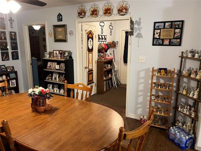 Dining room with ceiling fan and dark colored carpet | Image 2