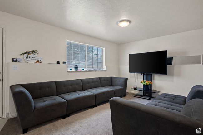 Living room with carpet floors and a textured ceiling | Image 22
