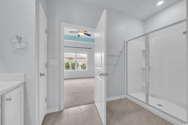 Bathroom featuring tile patterned flooring, baseboards, a stall shower, and ceiling fan | Image 10