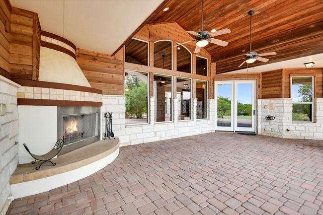 Another example of wise utilization of complimentary materials. This is your invitation to enjoy the seasons on the patio! Lighting, fans, arches, stone & tile with warm tones. West facing sunsets in the Texas sky in your own Forest on the Bluffs of Onion Creek. I hear a story coming to life! | Image 24