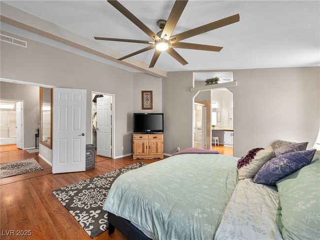 Bedroom featuring visible vents, connected bathroom, baseboards, and wood finished floors | Image 30