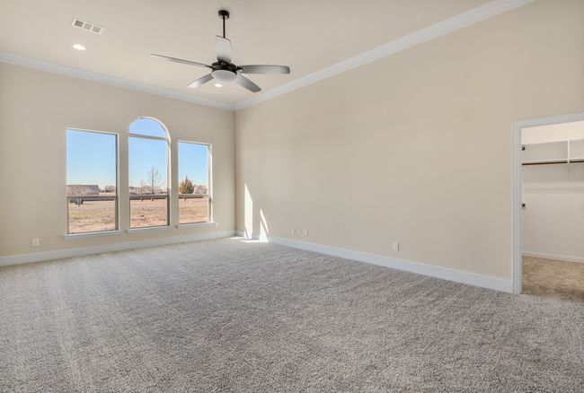 Empty room with a ceiling fan, ornamental molding, light colored carpet, baseboards, and recessed lighting | Image 14