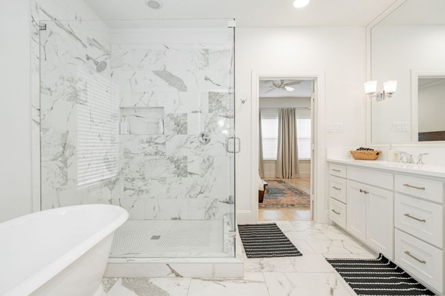 Bathroom with a freestanding tub, a ceiling fan, vanity, marble finish floor, and a glass shower | Image 20