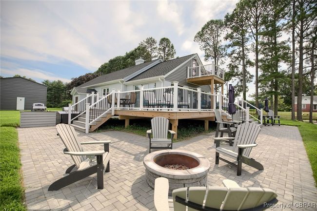 Back of house featuring a wooden deck, a patio area, and a fire pit | Image 21