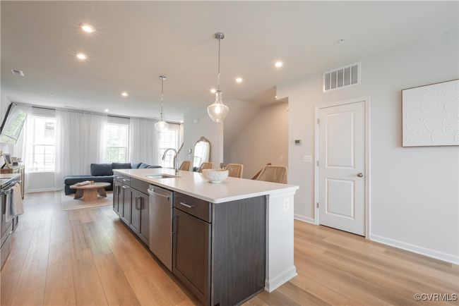 Kitchen with visible vents, stainless steel dishwasher, a sink, light wood-style floors, and open floor plan | Image 10