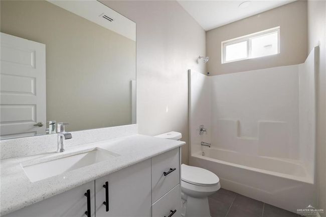Full bathroom with toilet, tile patterned flooring, vanity, and tub / shower combination | Image 11