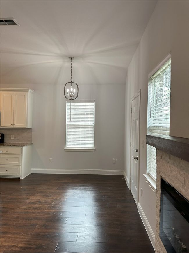 Unfurnished dining area with a chandelier, plenty of natural light, and dark wood-style floors | Image 10