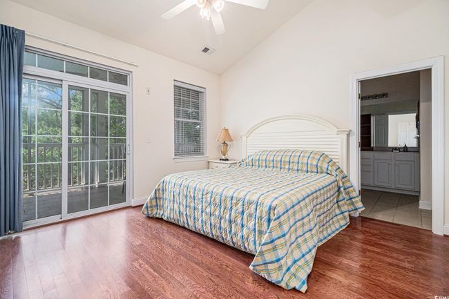 Bedroom with vaulted ceiling, access to outside, wood finished floors, ceiling fan, and baseboards | Image 14