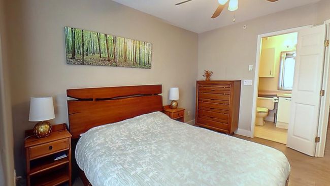 Bedroom with ceiling fan, ensuite bath, wood finished floors, and baseboards | Image 13