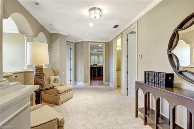 Living area with visible vents, ornamental molding, light carpet, and ornate columns | Image 5