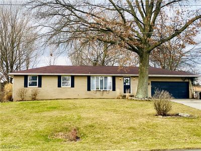 Ranch-style home with a garage and a front yard | Image 1