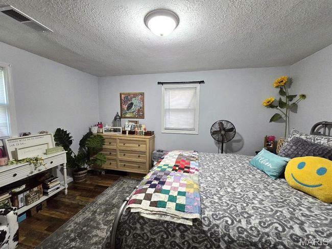 Bedroom featuring dark wood-style floors and a textured ceiling | Image 15