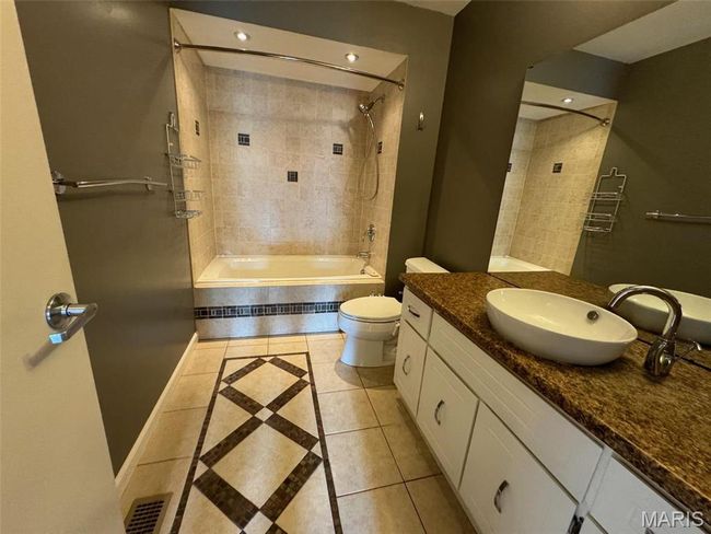 Full bathroom with toilet, tiled shower / bath combo, vanity, and tile patterned flooring | Image 27