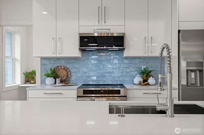 The backsplash is such a focal point of the kitchen and an absolute work of art! All the appliances are sleek...even the microwave! | Image 13