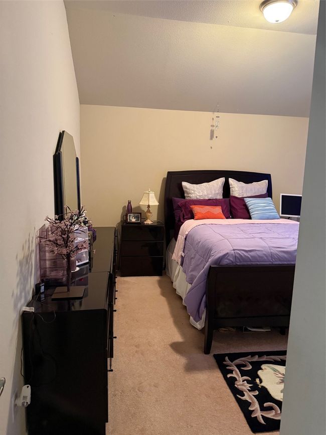 Bedroom with light carpet and vaulted ceiling | Image 36