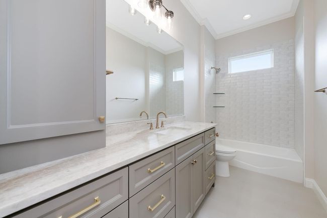 Full bath featuring vanity, shower / tub combination, and ornamental molding | Image 33