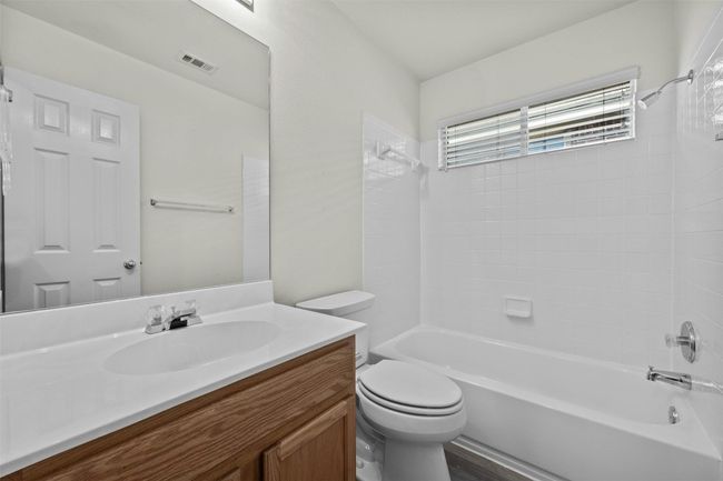 Charming hall bath located between two secondary bedrooms, offering easy access and a convenient layout. Features include a tub/shower combo, vanity with storage, and neutral finishes throughout. | Image 26