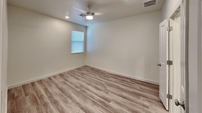 Empty room with a ceiling fan, visible vents, and light wood-type flooring | Image 11