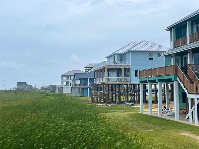 This photo reinforces the consistency of elevation and design quality throughout the beachfront row. The 5142 Blue Water Hwy home stands out not just for size, but for the luxury lifestyle and rental income potential it represents. | Image 16