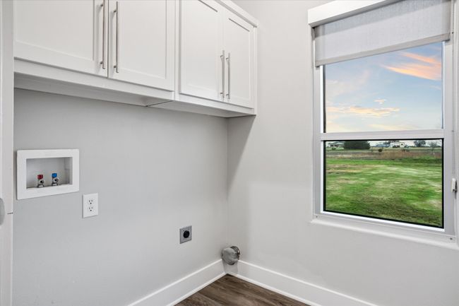Clothes washing area featuring washer hookup, electric dryer hookup, cabinets, and dark wood-type flooring | Image 23