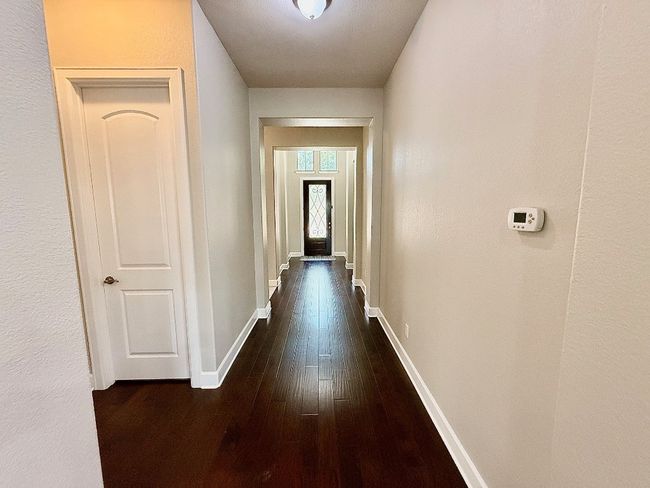 Hall with dark wood-style flooring and baseboards | Image 17