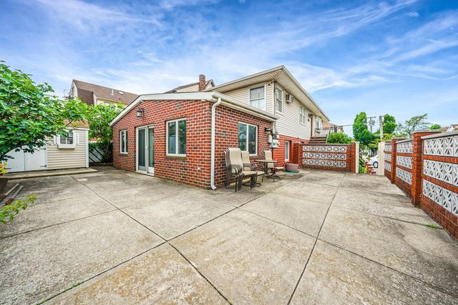 Back of house with brick siding, a patio area, and a chimney | Image 5
