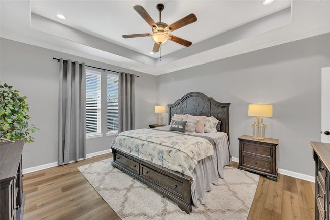 Bedroom with a raised ceiling, recessed lighting, light wood-style floors, and baseboards | Image 19