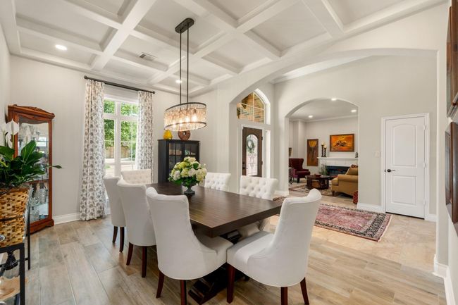 You and your guests will certainly dine in style in this amazing formal dining room! Featuring a gorgeous modern chandelier, large window with blinds, neutral paint, high trey ceilings and vinyl flooring. Perfect space to entertain family and friends. | Image 10