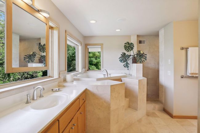 This primary bathroom says relaxation and retreat! Gorgeous tile work, jacuzzi tub and large walk-in shower! Sit back, soak and relax after a long day! | Image 25