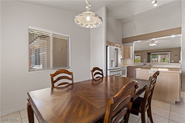 Dining space featuring light tile patterned floors, ceiling fan, and high vaulted ceiling | Image 19