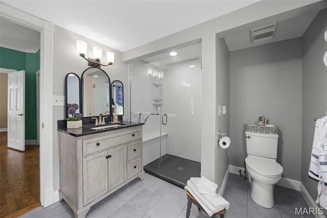 Bathroom featuring vanity, a stall shower, tile patterned floors, and ornamental molding | Image 17