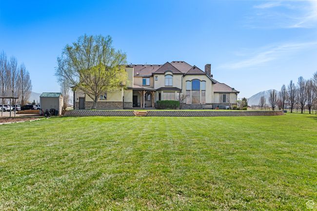 View of front of property with a front yard, a chimney, an outdoor structure, and stucco siding | Image 9