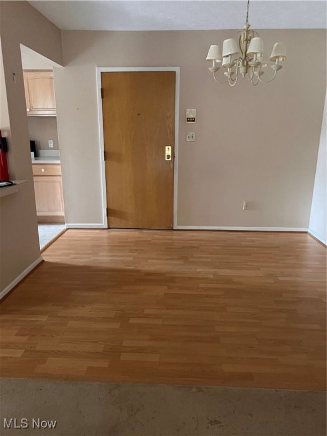Unfurnished dining area with a chandelier and light wood-style floors | Image 5