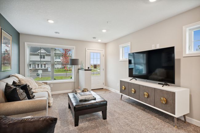 The main level is amplified by the warm natural light from the large windows. *Please note, photos are of a model and are not the actual home. | Image 9