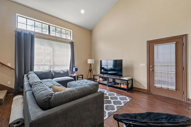Living area with high vaulted ceiling and wood finished floors | Image 8