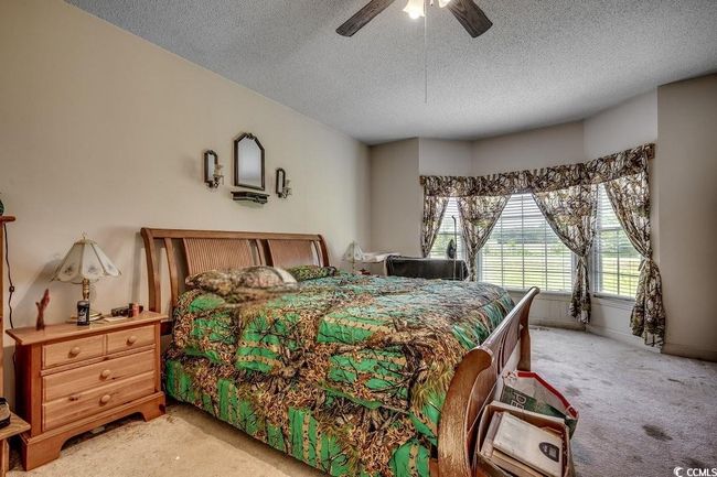 Bedroom featuring light colored carpet, a textured ceiling, and a ceiling fan | Image 16