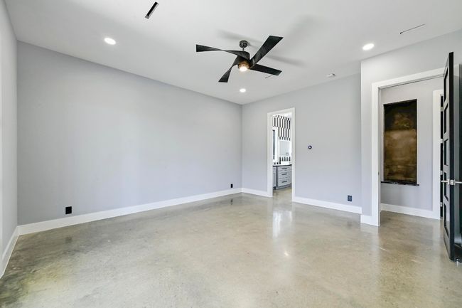 The oversized primary suite is a private retreat for rest and relaxation with tall ceilings, LED recessed lighting, and a modern ceiling fan. | Image 20