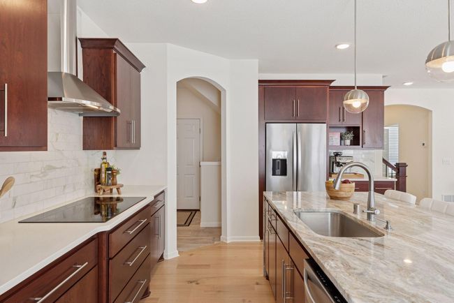 Marble waterfall island top, real cherrywood cabinets in a modern design, spacious and inviting kitchen | Image 12