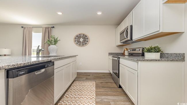 Kitchen featuring light stone countertops, appliances with stainless steel finishes, and sink | Image 4