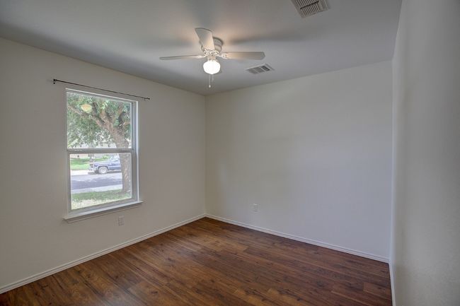 Unfurnished room featuring a ceiling fan, dark wood-style floors, and baseboards | Image 35