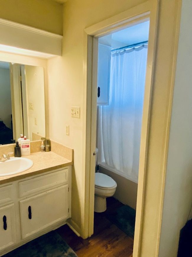 Bathroom with shower / tub combo with curtain, vanity, toilet, and wood finished floors | Image 9