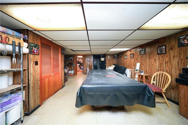Playroom featuring wooden walls, pool table, a paneled ceiling, and tile patterned floors | Image 20