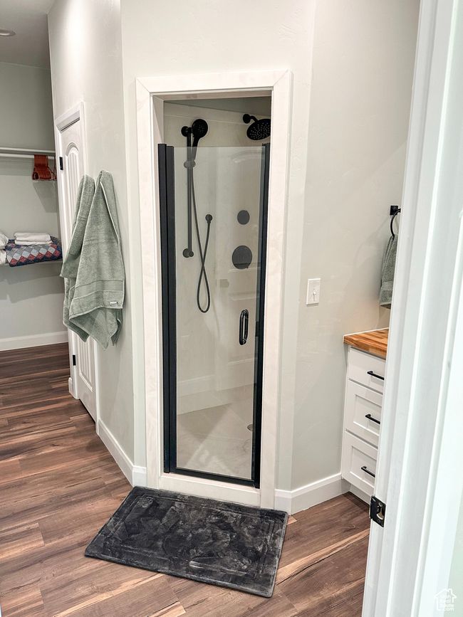 Bathroom featuring wood finished floors, vanity, baseboards, and a shower stall | Image 32
