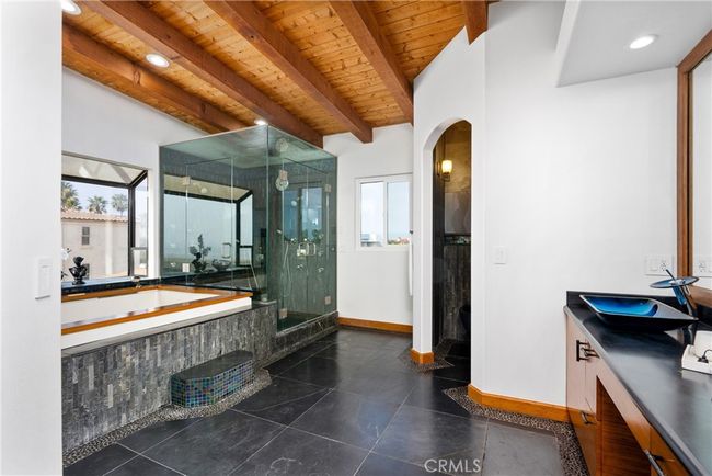 A master bathroom designed with luxury, featuring dual sinks and a glass-enclosed steam shower with multiple shower heads. | Image 40