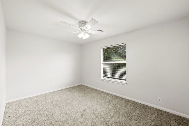 Carpeted spare room with baseboards and a ceiling fan | Image 12