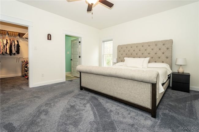 Bedroom featuring carpet flooring, a ceiling fan, a walk in closet, and baseboards | Image 18