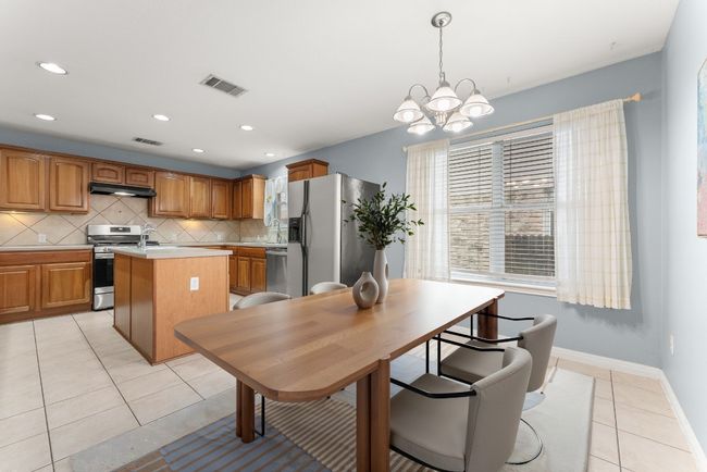 Photo virtually staged. Dining area with recessed lighting, a chandelier, light tile patterned floors, and visible vents | Image 12