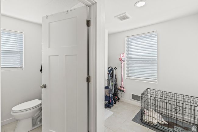 Bathroom featuring toilet, tile patterned flooring, and baseboards | Image 16