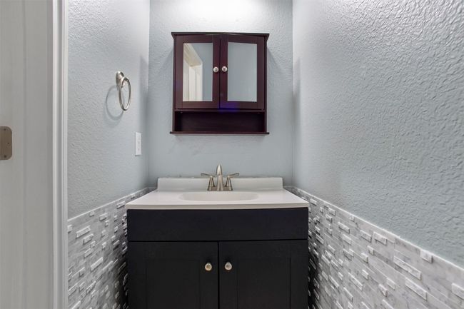 Bathroom with vanity, a wainscoted wall, and tile walls | Image 32