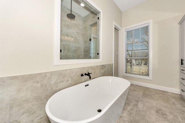 Full bathroom featuring a soaking tub, tile walls, and a tile shower | Image 26